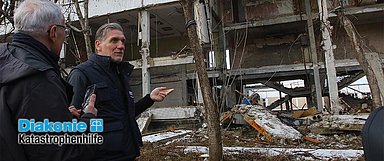Martin Keßler (r.), Leiter der Diakonie Katastrophenhilfe, beim Besuch im Osten der Ukraine im Februar 2024. Er besichtigte dabei die Zerstörungen und Reparaturen. (Foto: Roman Malkon/Diakonie Katastrophenhilfe)