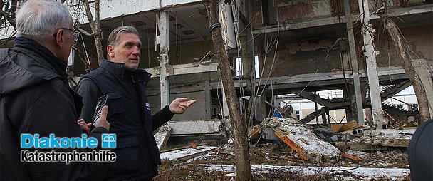 Martin Keßler (r.), Leiter der Diakonie Katastrophenhilfe, beim Besuch im Osten der Ukraine im Februar 2024. Er besichtigte dabei die Zerstörungen und Reparaturen. (Foto: Roman Malkon/Diakonie Katastrophenhilfe)